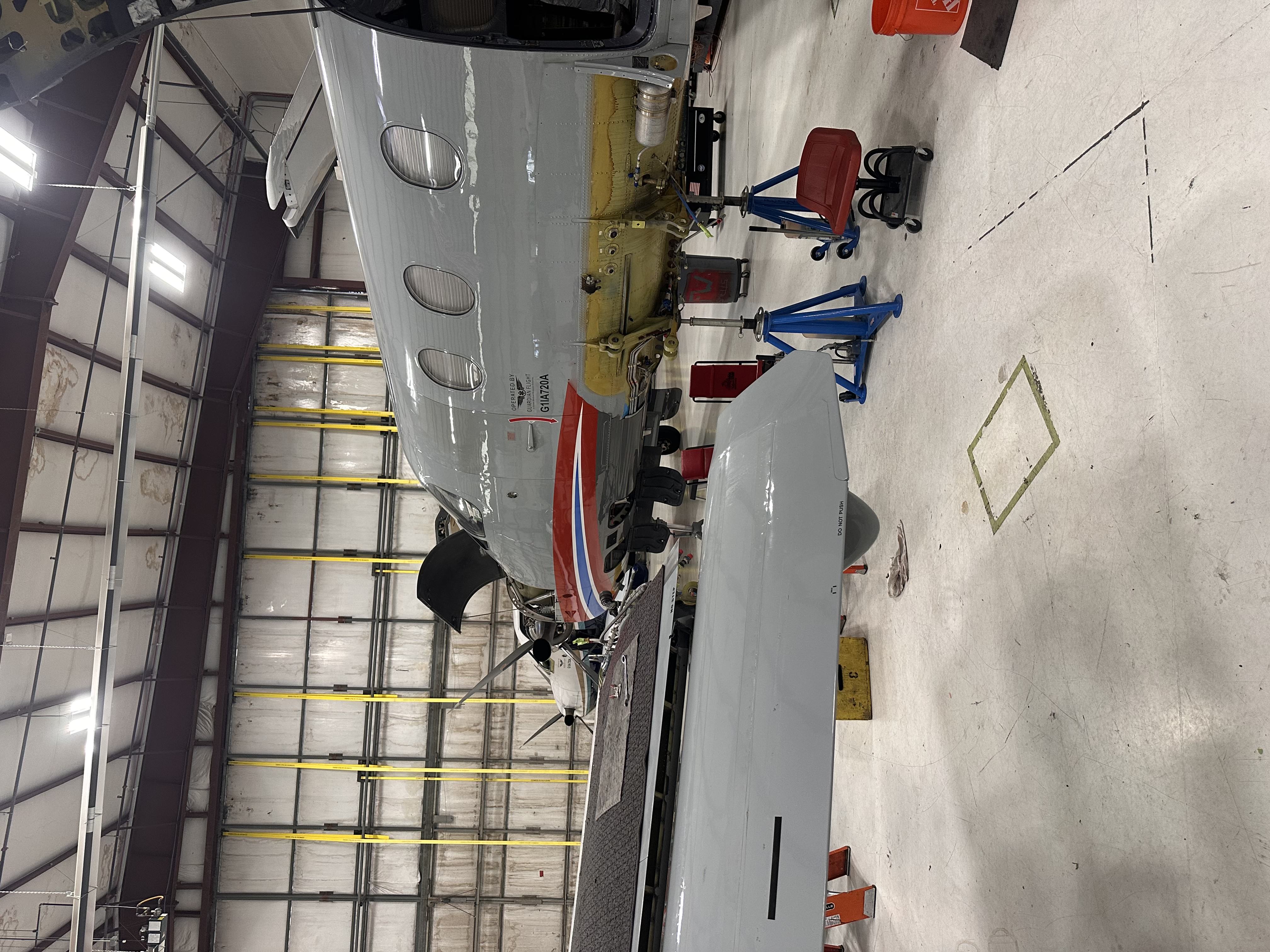 Aircraft undergoing maintenance on jacks inside the hangar